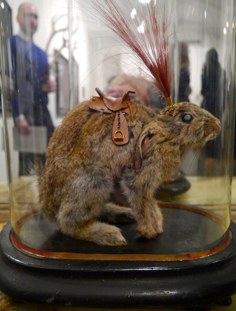 Brown Caviar, 2014. Baby rabbit, leather, hematite, mystic spinel, smoky quartz, sterling silver, gold plate, egret feathers, antique glass dome.